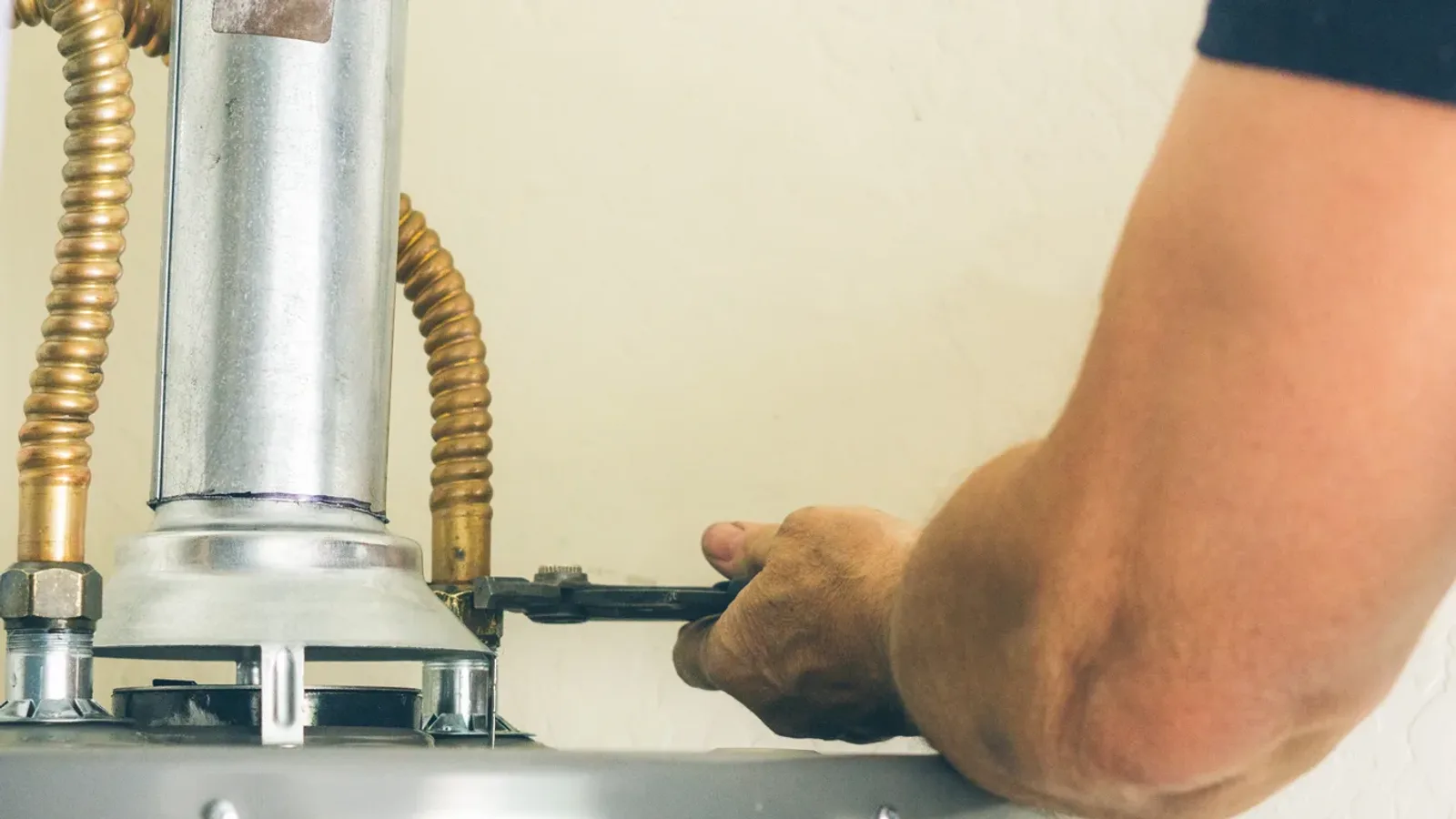 A residential tank water heater being worked on at its supply connections