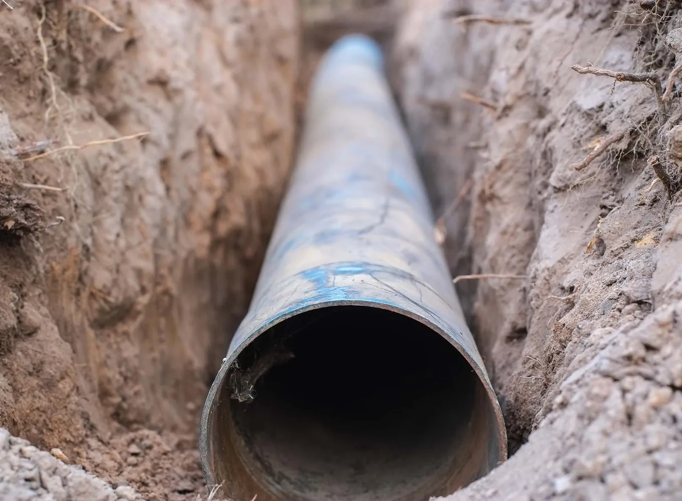 A new sewer pipe laid along the bottom of an open trench