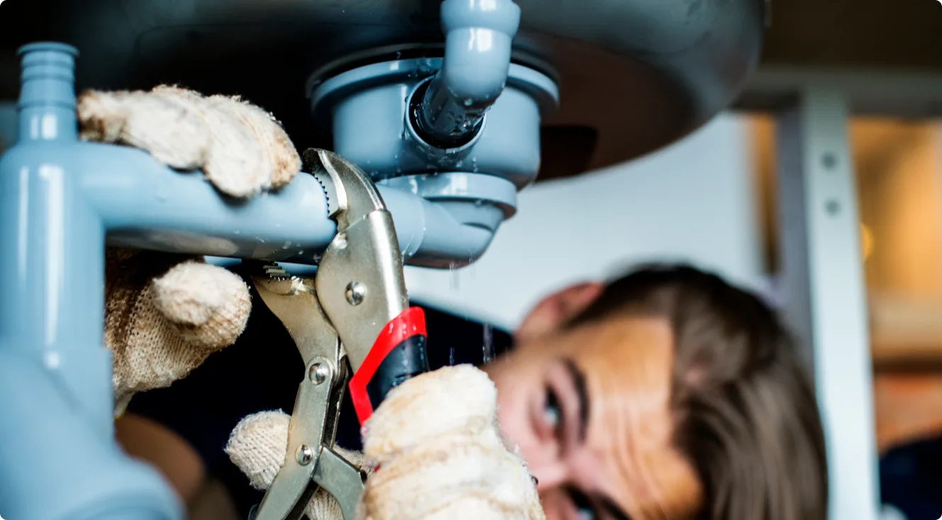 Plumber working on the supply lines under a bathroom sink